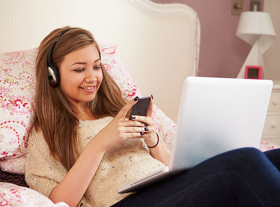 teen texting in bed