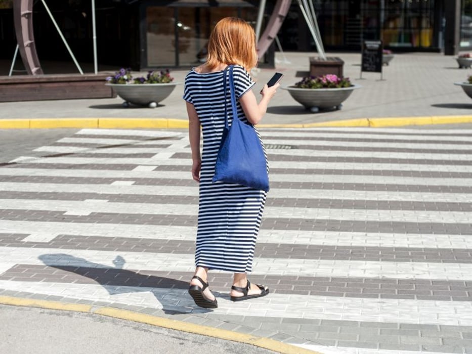 pedestrian with smartphone in crosswalk