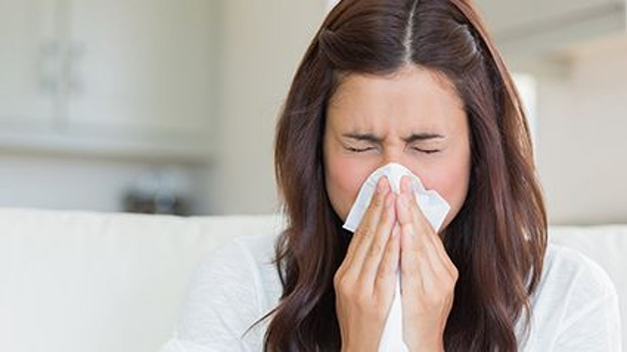 a girl sneezing in the tissue