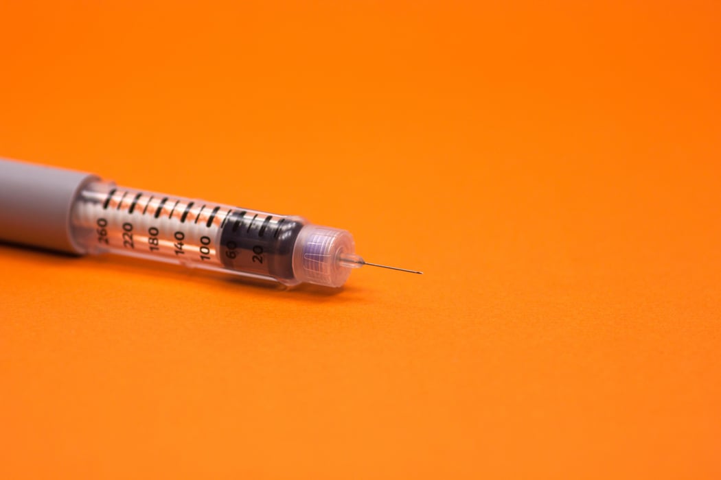 needle in orange background injector pen