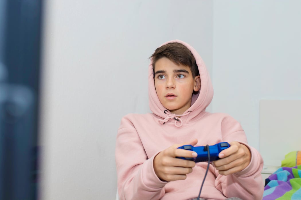 young teenager with game joystick playing at home