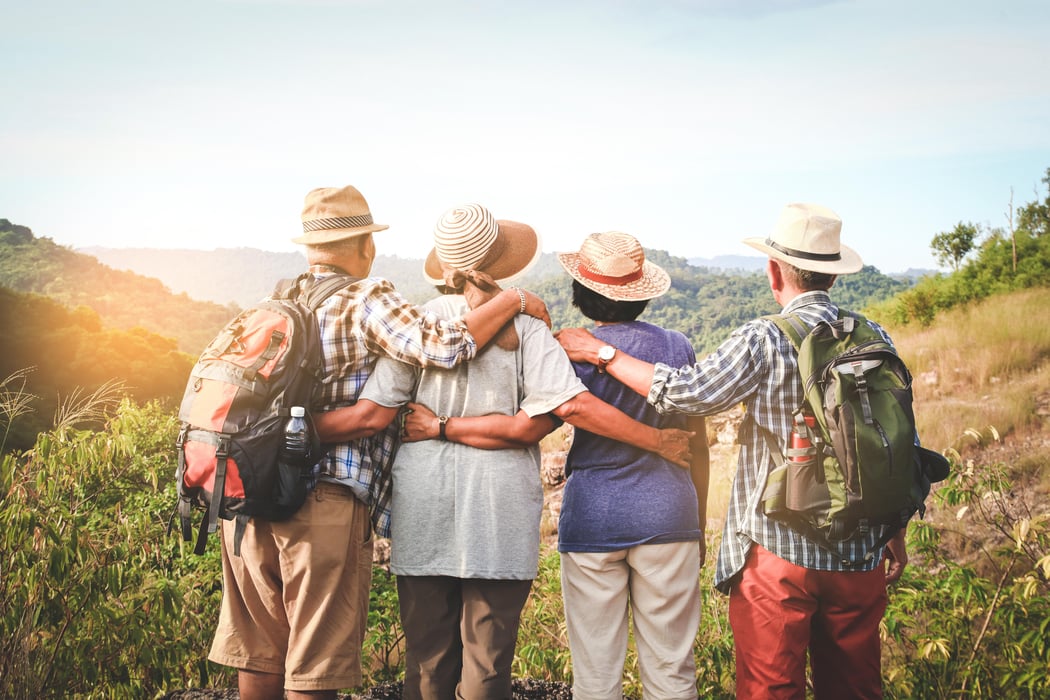 A group of Asian seniors hiking and standing on high mountains enjoying nature. Senior community concepts