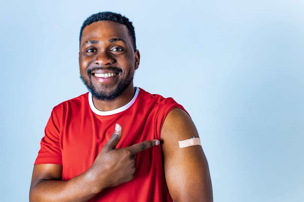 afro american sportsman showing his arm after receiving a vaccine in studio