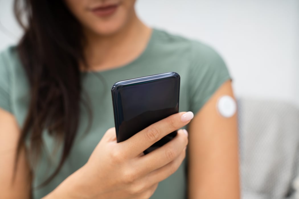 Woman Checking Blood Sugar Level On Smart Phone