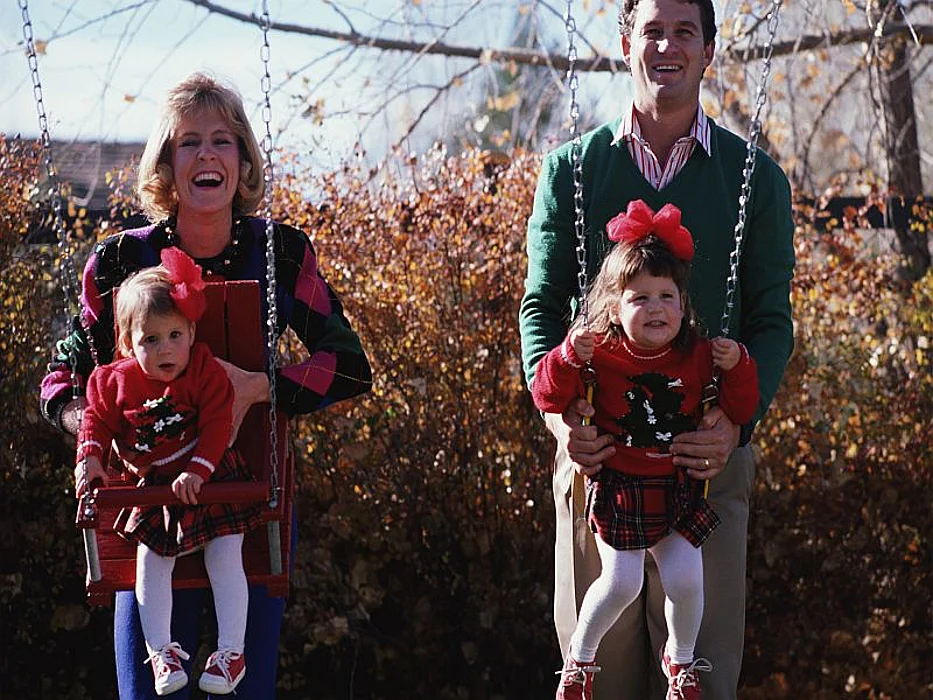 parents swinging their children