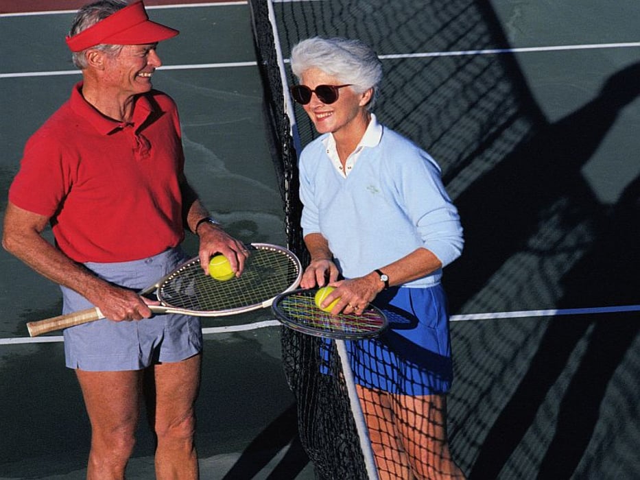 elderly couple playing tennis