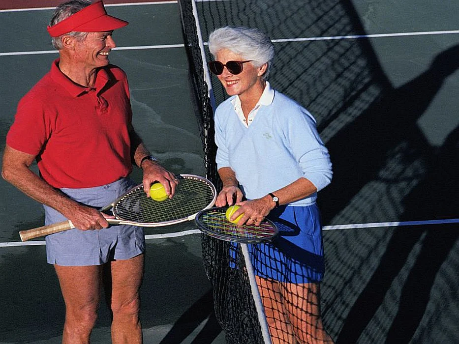 elderly couple playing tennis