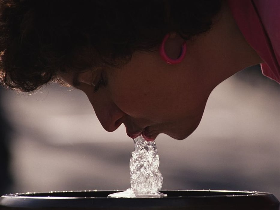 woman drinking from the water fountain
