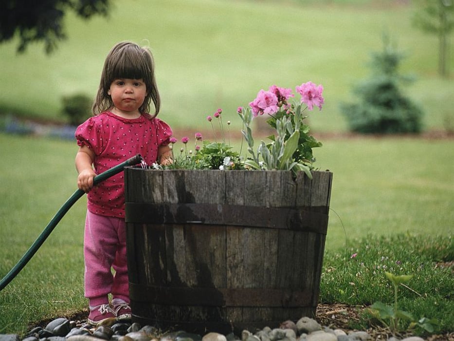 a little girl watering flowers