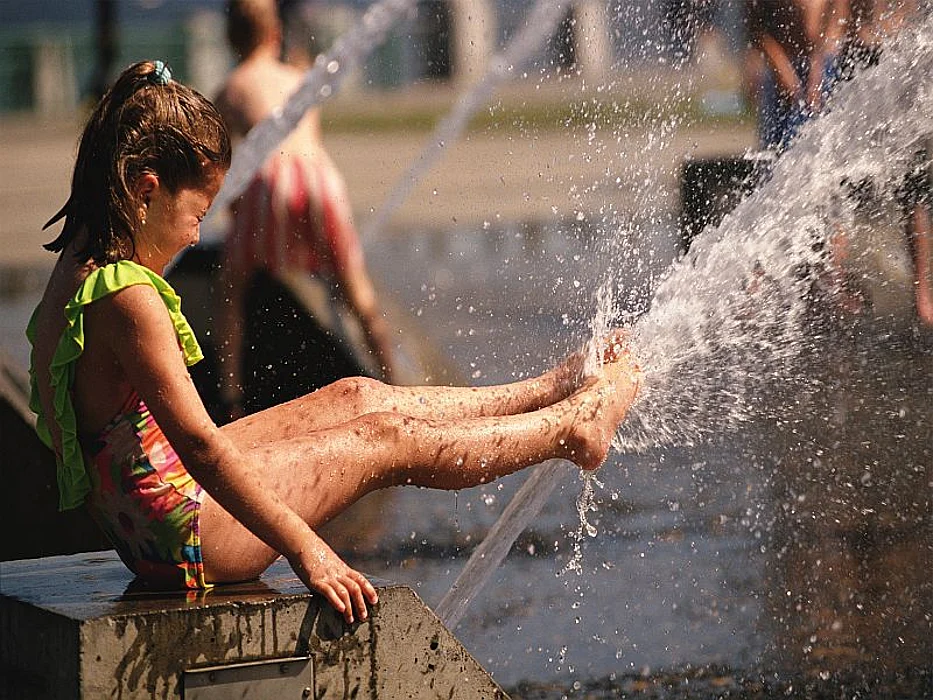girl playing under the sprinkler