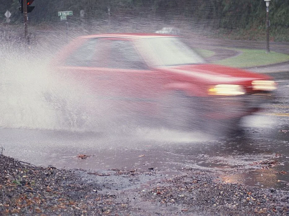 red car driving through water