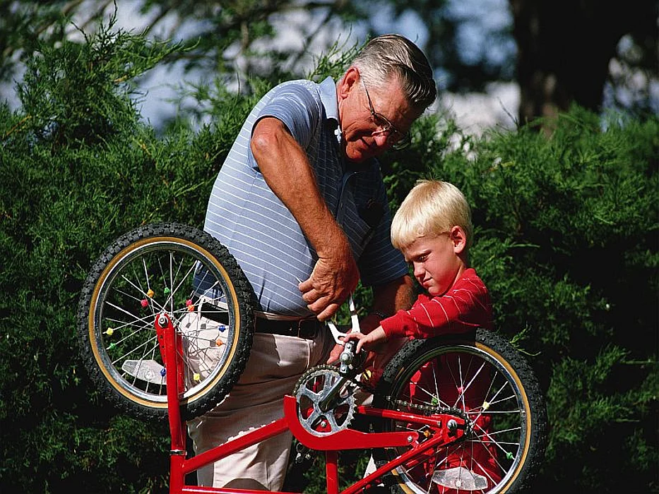 man fixing a bike with a boy