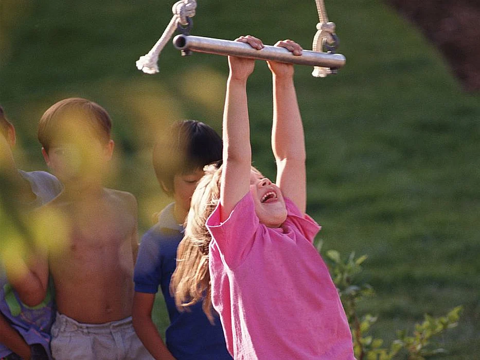 child hanging from swing
