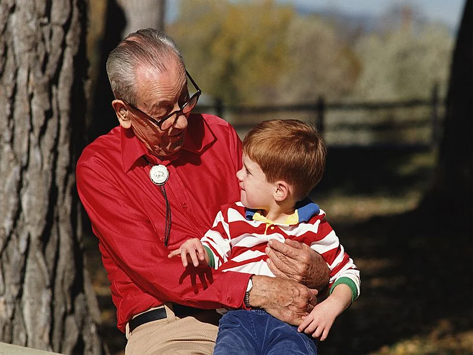 boy sitting on older man\'s lap