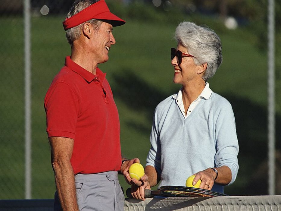 man and woman playing tennis