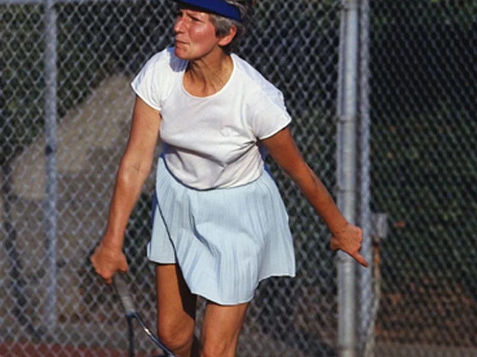 older woman playing tennis