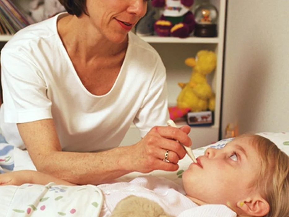 mother checking the girl\'s temperature
