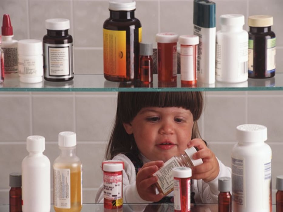 little girl checking a medicine cabinet