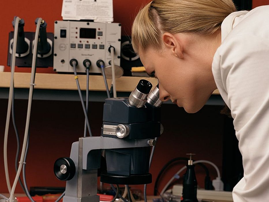 woman looking through the microscope