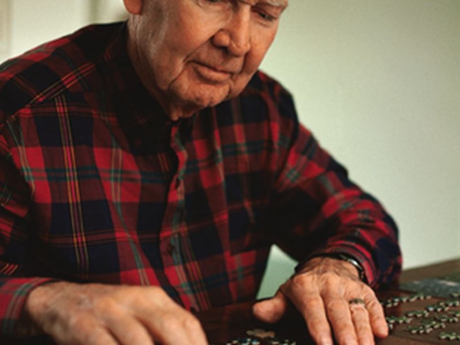 man doing jigsaw puzzle