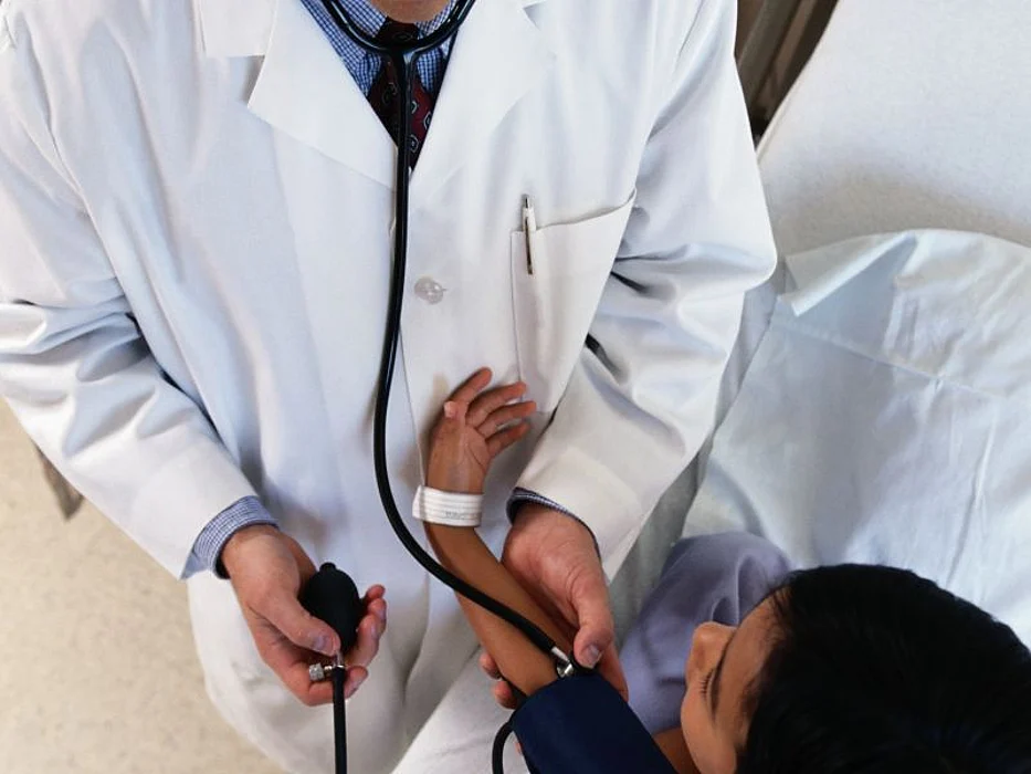 doctor taking patient\'s blood pressure