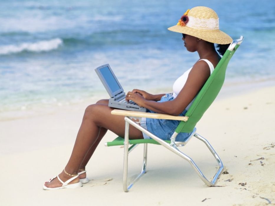 female with a computer at the beach