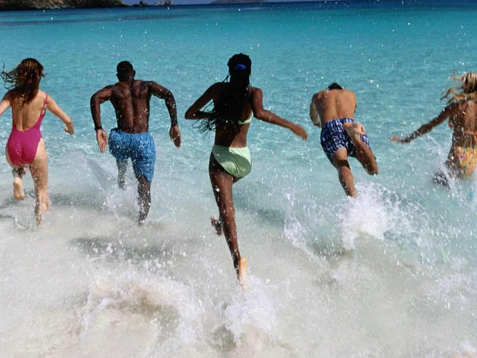 group of people jumping into the ocean