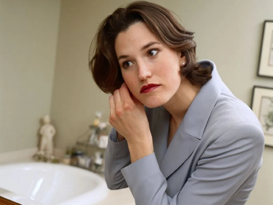 woman putting earrings on