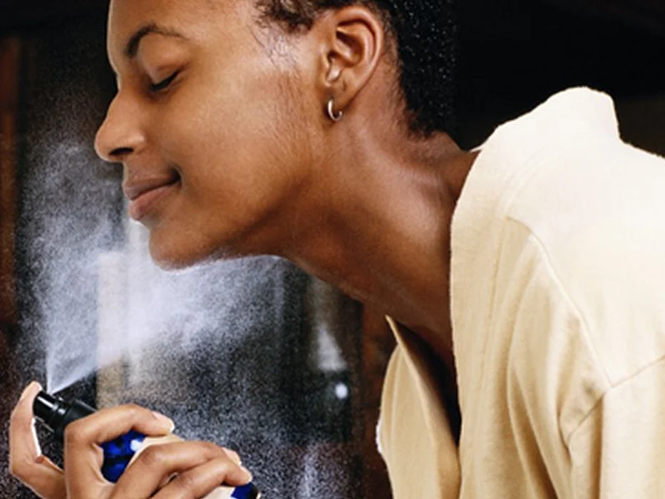 woman spraying perfume