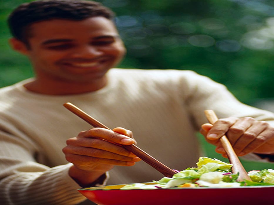 man serving salad from a bowl