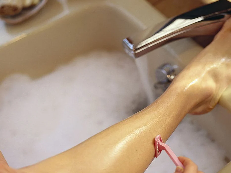 woman shaving her legs
