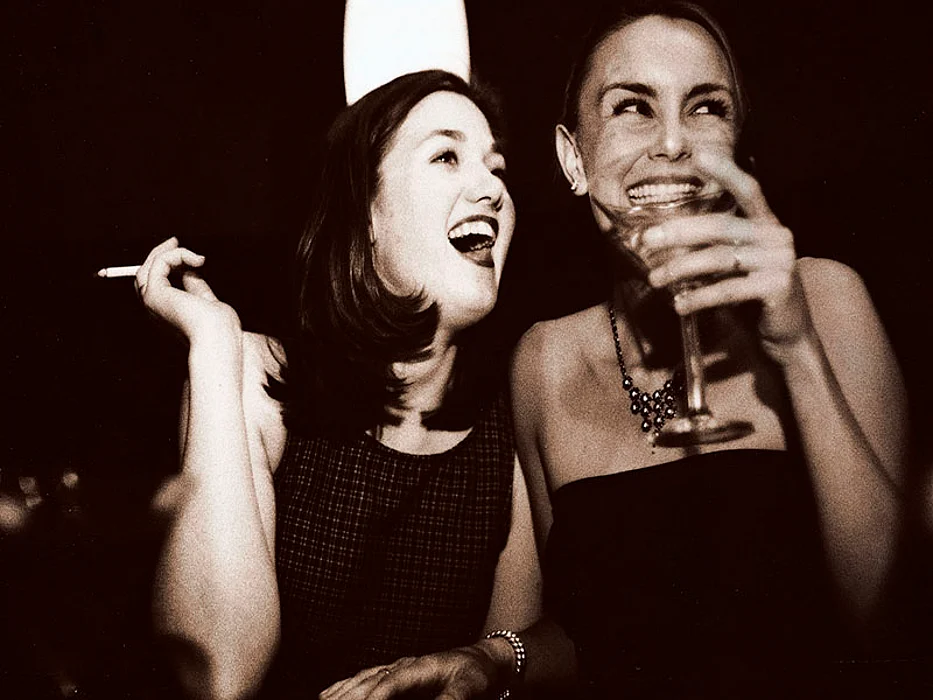 couple of women smoking and drinking