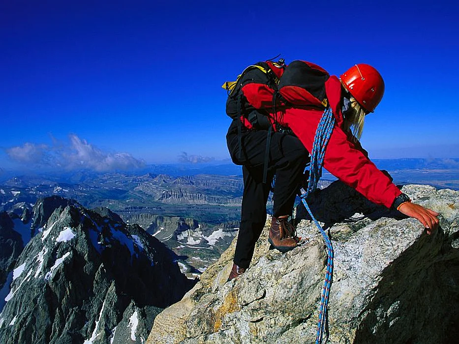 men climbing to the top of