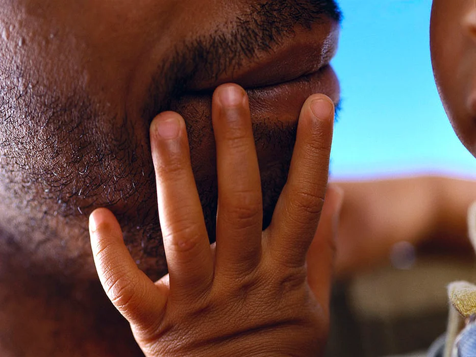 baby touching father\'s face