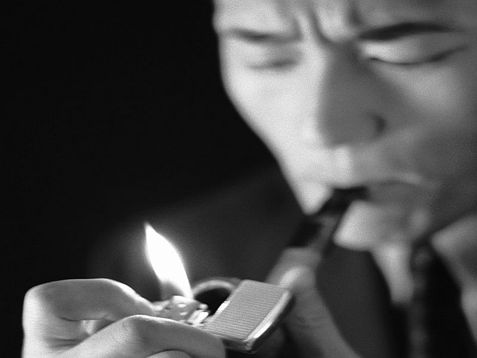 man lighting up a cigar
