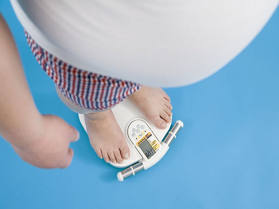 obese man weighs himself