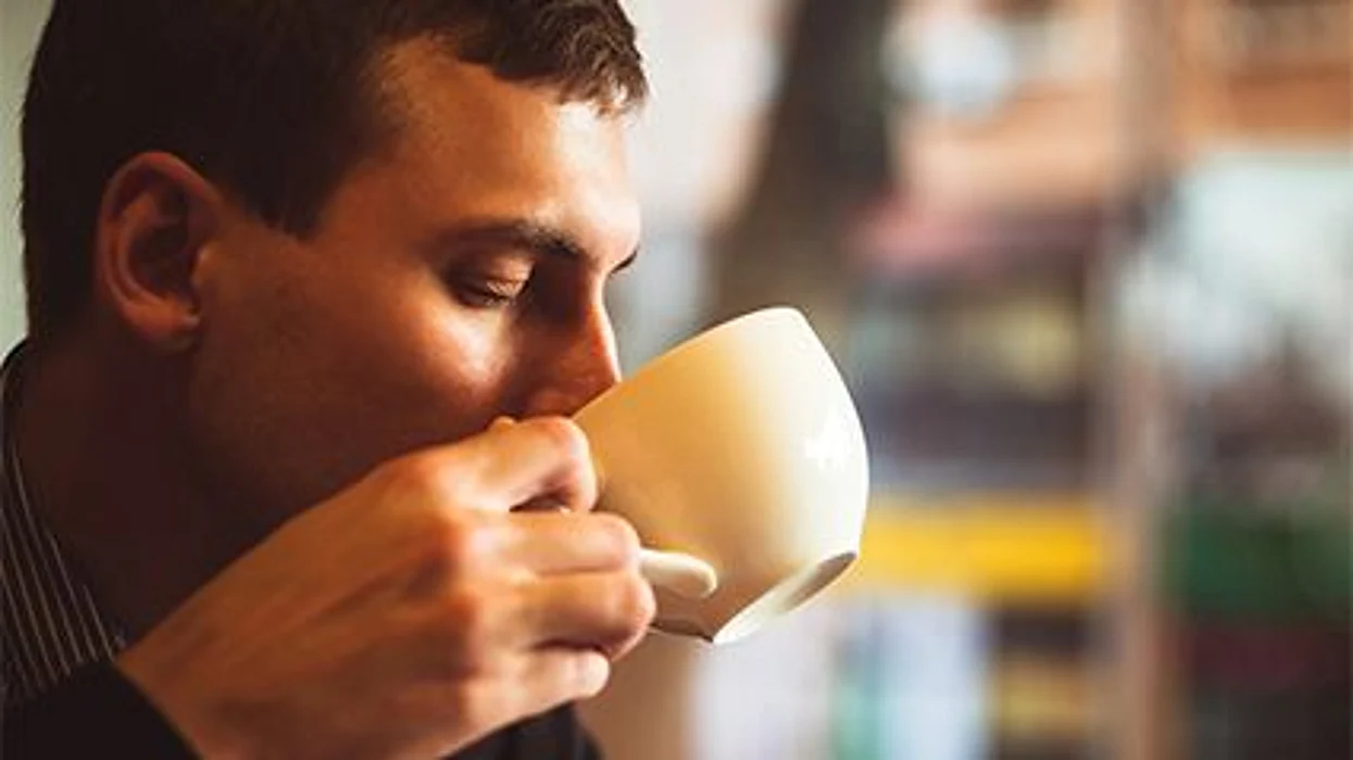 man drinking from a cup