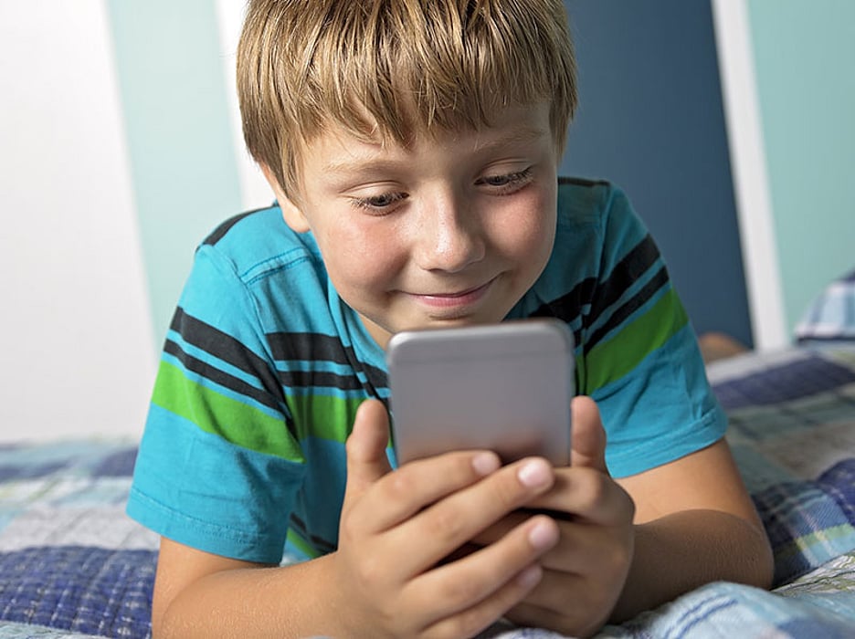 kid texting in bed