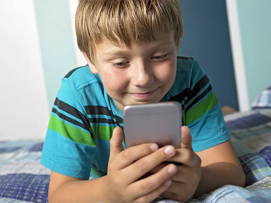 kid texting in bed