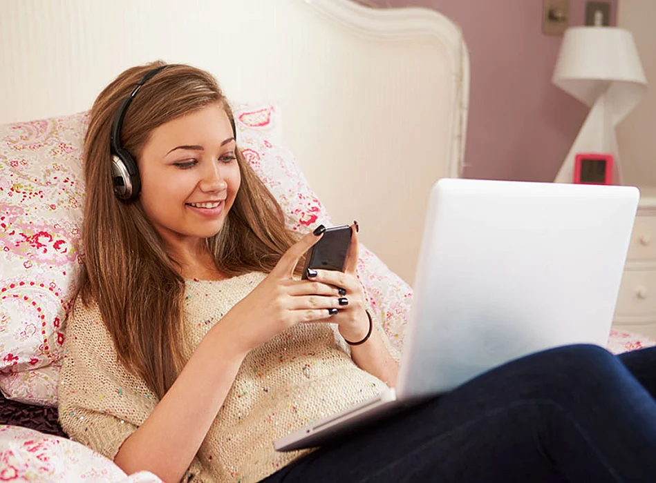 teen texting in bed