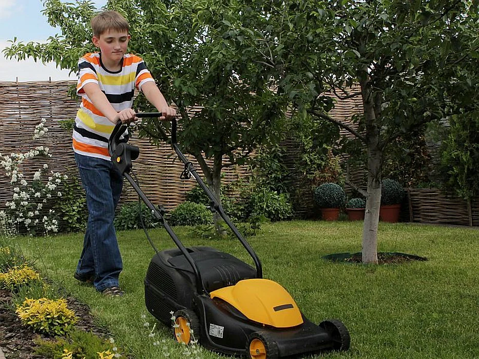 teen boy mowing lawn