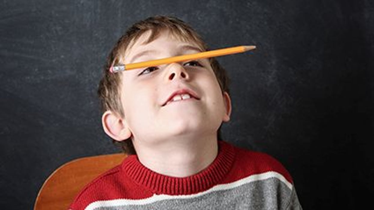 a boy balancing a pencil on his nose