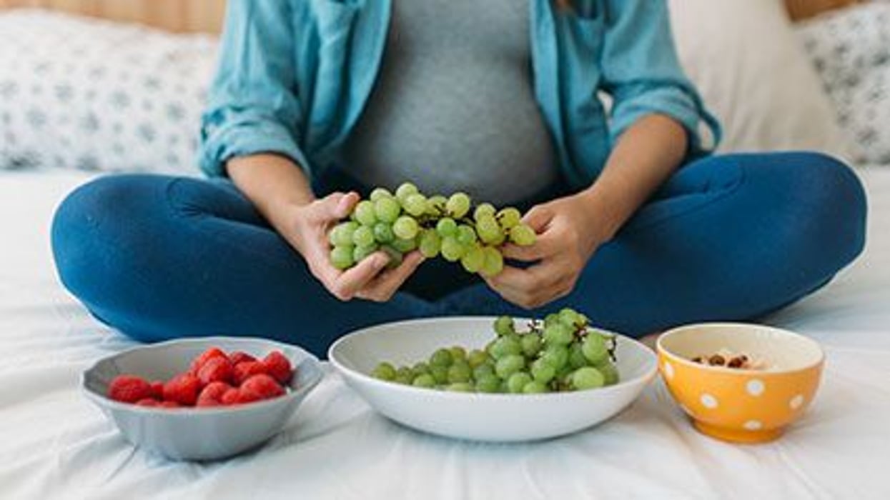 pregnant woman eating grapes