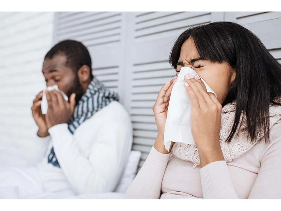 Man and woman blowing their noses