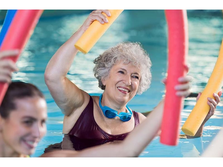 women exercising in the pool with a noodle