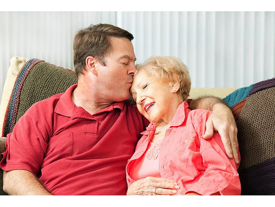 man kissing a woman on the forehead