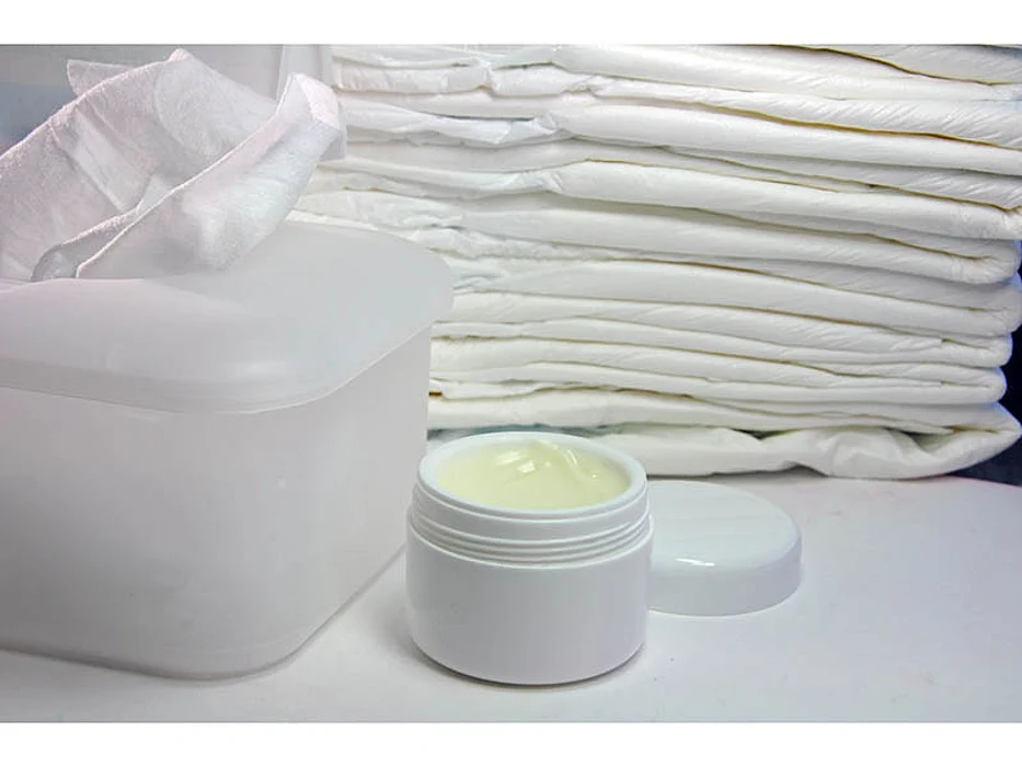 a jar of cream, tissues and towels folded