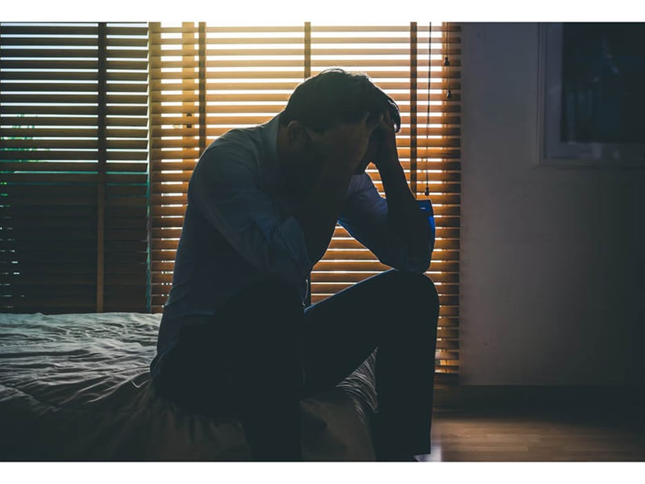 depressed man sitting on the bed