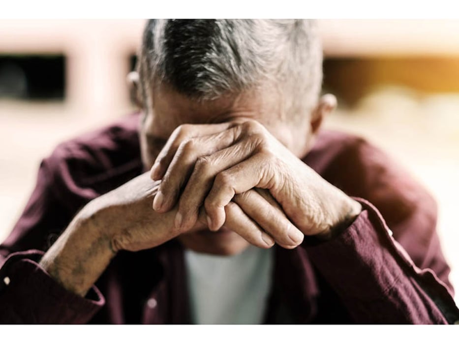 depressed man with hands over his face