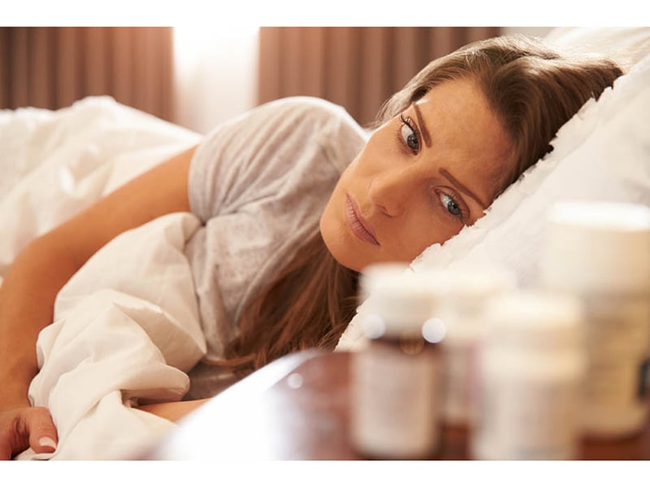 depressed woman lying in bed